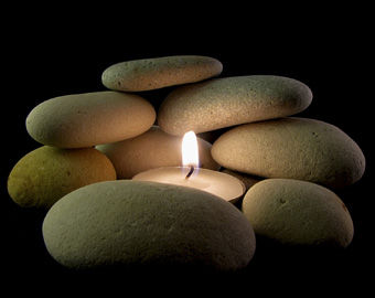 Mit ganz einfachen Tricks kann man den Wellnesscharakter des Badezimmers hervorheben, zum Beispiel mit aufeinander gelegten Steinen und einer Kerze dazwischen, wie es das Bild zeigt.